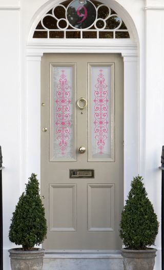 beige traditional front door with decorative stickers on glazing