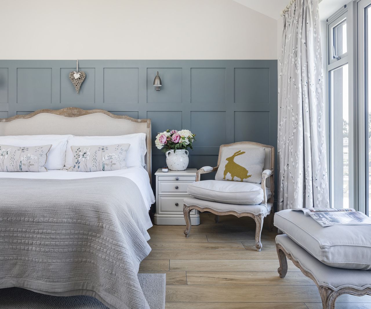 A wood-panelled bedroom with a large classic style bed and furniture