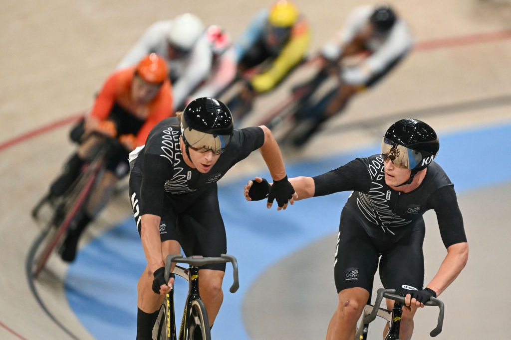 New Zealand's Aaron Murray Gate relays New Zealand's Campbell Stewart during the men's track cycling madison final of the Paris 2024 Olympic Games at the Saint-Quentin-en-Yvelines National Velodrome in Montigny-le-Bretonneux, south-west of Paris, on August 10, 2024. (Photo by SEBASTIEN BOZON / AFP)