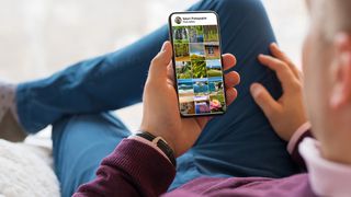 A person holding a phone, having an app open which shows a Nature Photographer gallery open