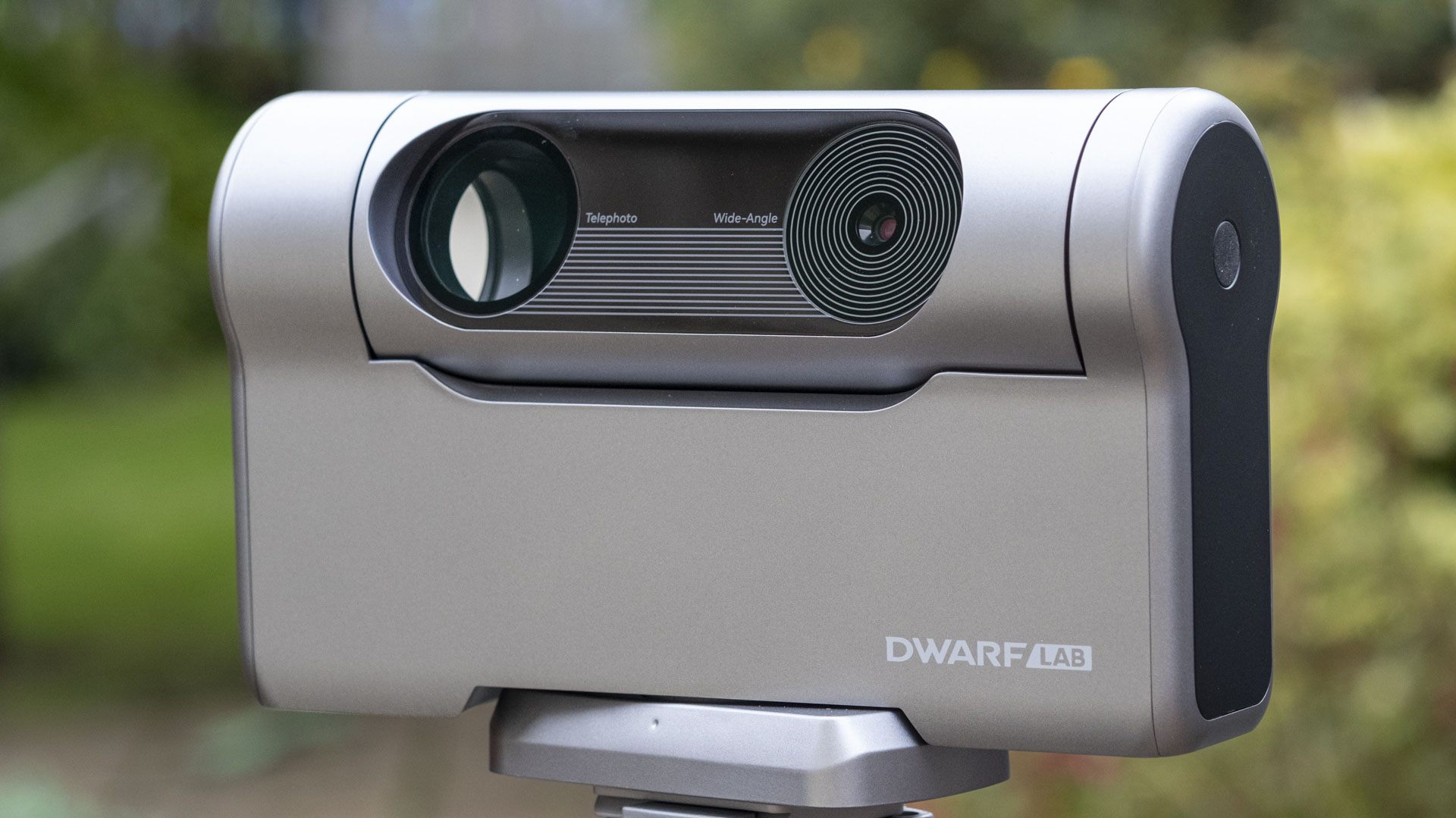 The Dwarf III smart telescope photographed in a garden, showing the front of the device