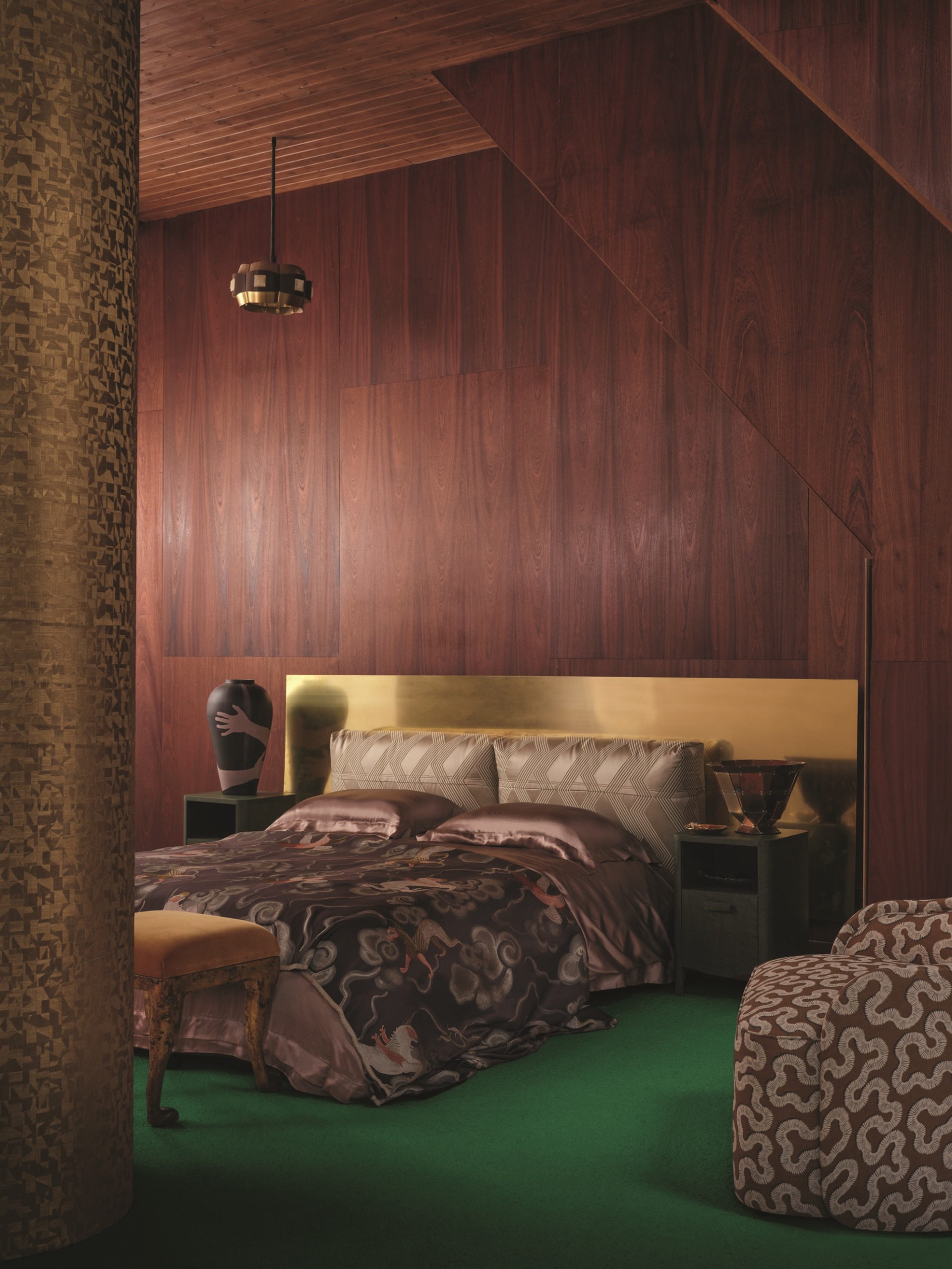 a dark wood paneled bedroom with a brass headboard and silk sheets, with a green floor