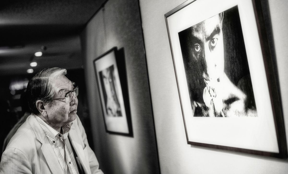 Japanese photographer and filmmaker Eikoh Hosoe looks at a print of one of his portraits of novelist Yukio Mishima in Tokyo