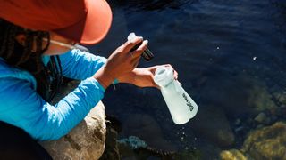 A woman using the Katadyn BeFree AC 1.0 L Water Filter Bottle to filter water