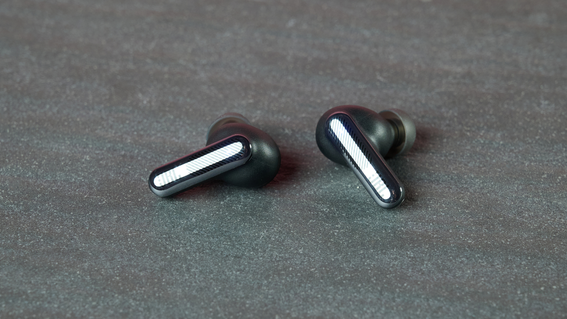 JBL Live Beam 4 earbuds on table