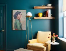 A corner with mustard yellow chair and teal walls