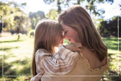 Mother and daughter embracing in rural pasture