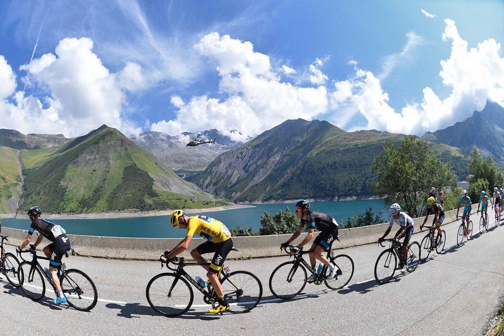 The GC group rides past an Alpine lake during stage 18