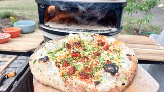 Gozney Arc pizza oven with a pizza coming out