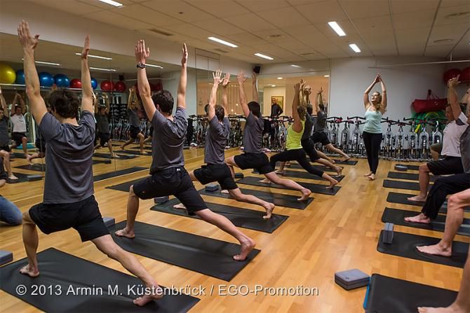 Team BMC assumes Warrior 1 (Virabhadrasana 1) pose during a yoga practice at team camp.