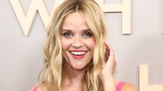 Reese Witherspooon smiling while wearing deep pink lipstick, one of the top fall makeup looks