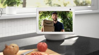 The amazon echo show 10 on a kitchen countertop showing a live feed from a Ring Video Doorbell