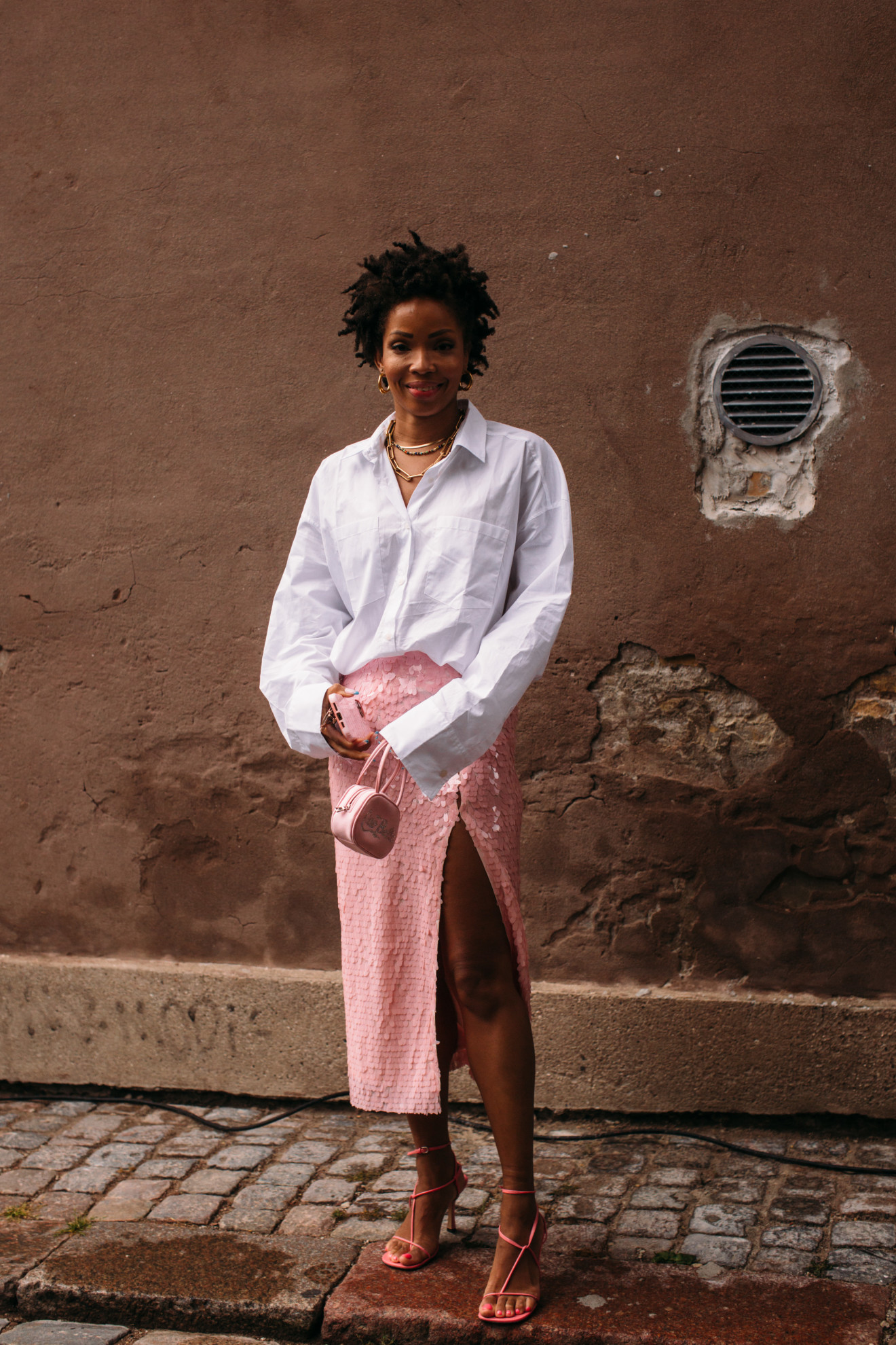 woman wearing button-down shirt, pink skirt, and sandals