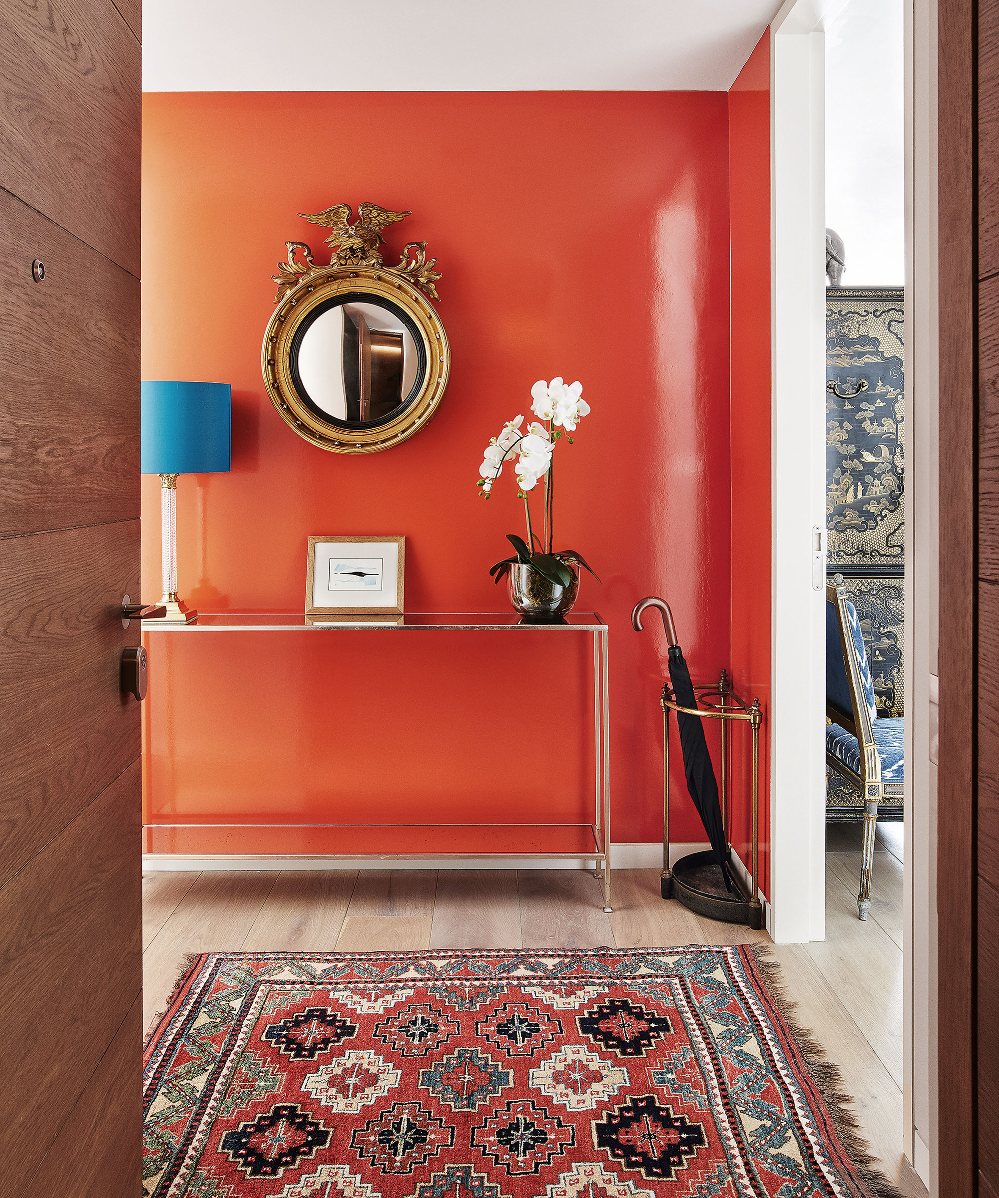 Hallway with orange and white color scheme and a patterned rug.