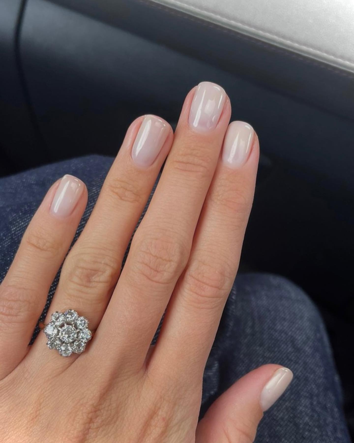 Una manicure corta e lattiginosa con una finitura scintillante