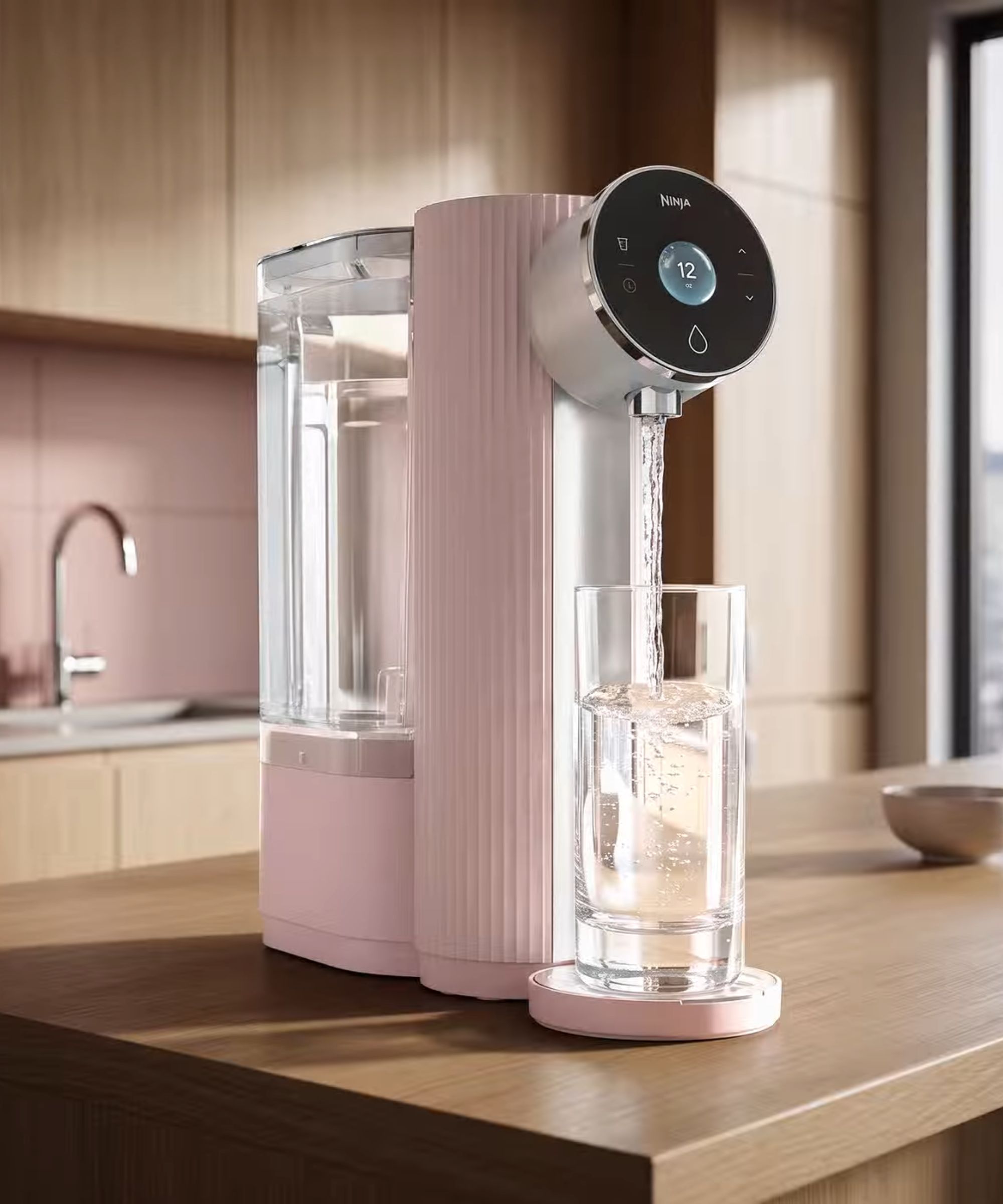 A pink water fitler system on a light wood kitchen counter.