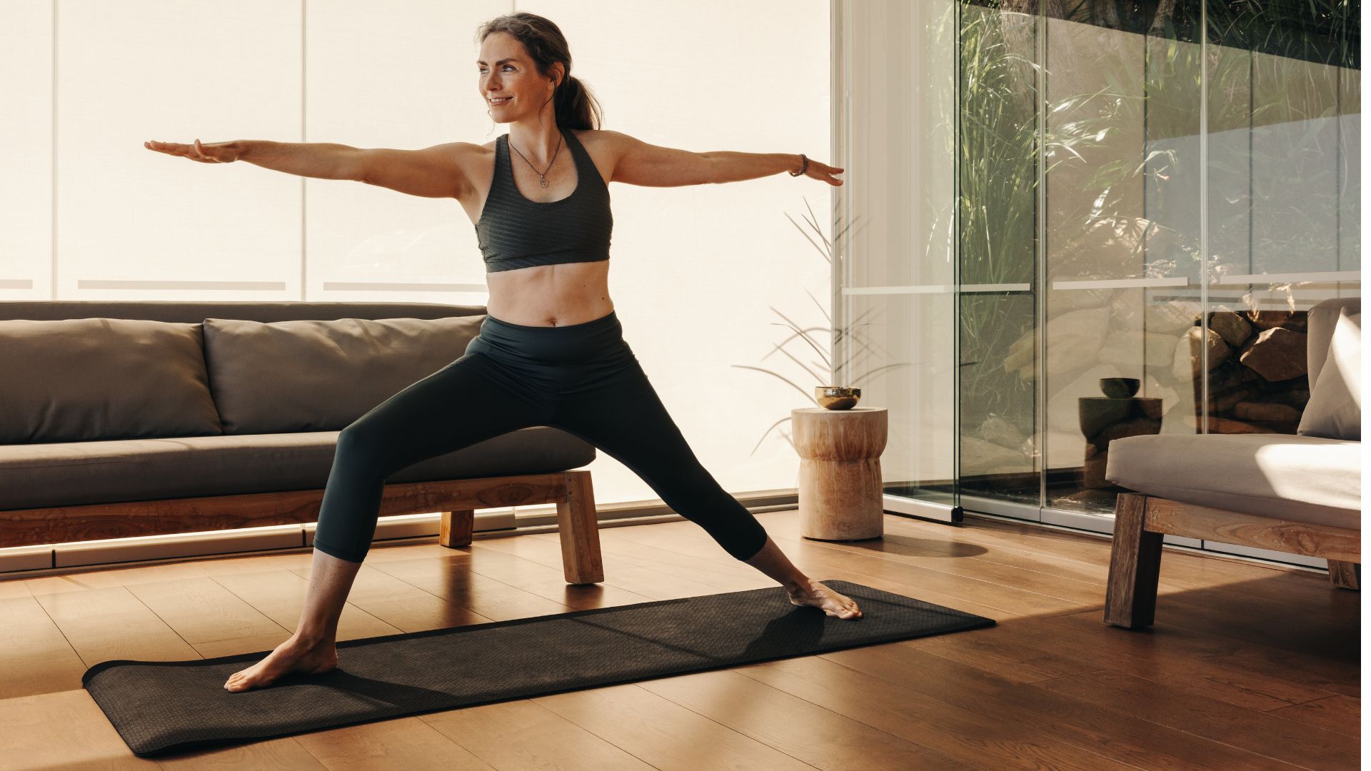 Woman doing Pilates on yoga mat at home