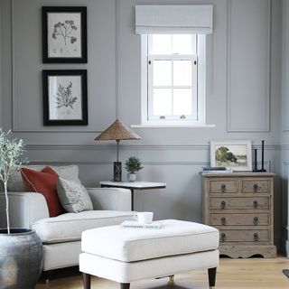 a neutral look living room with a cream armchair, matching footstool and velvet cushions