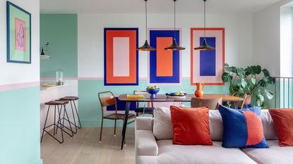 A modern living and dining space with geometric shapes painted onto the walls in a palette of mint green, bright red, bubblegum pink, and electric blue. Wood flooring with a taupe sofa and cream patterned rug.