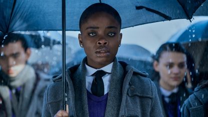 Joy Sunday as Bianca, Wednesday's rival in Netflix's "Wednesday" holding an umbrella in the rain