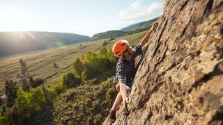 Guy rock climbing at sunset