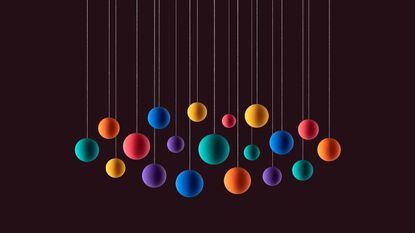 rainbow colored spheres hanging on string with black background