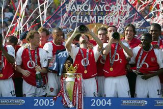 Arsenal players celebrate with the Premier League trophy at the end of their Invincible season in May 2004.