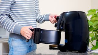Person loading food into an air fryer