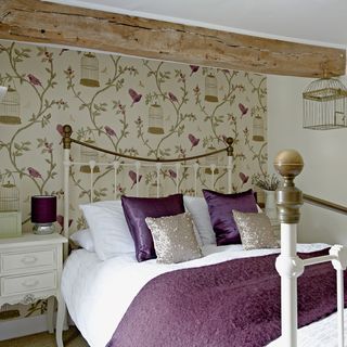 bedroom with wallpaper and purple beddings