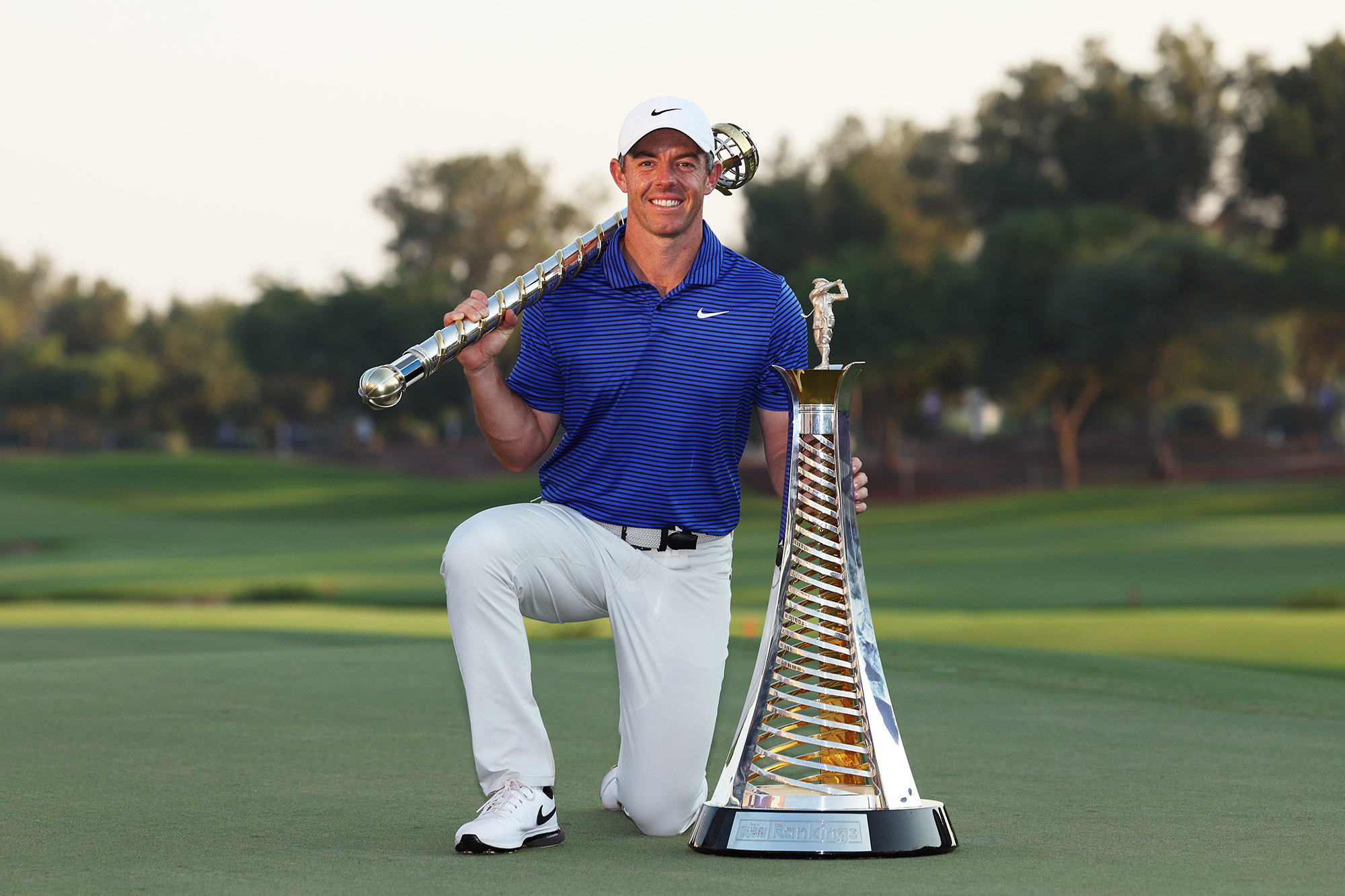 Rory McIlroy posing with his Race To Dubai and DP World Tour Championship trophies in 2024