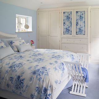 blue and white country bedroom with cream painted wardrobes