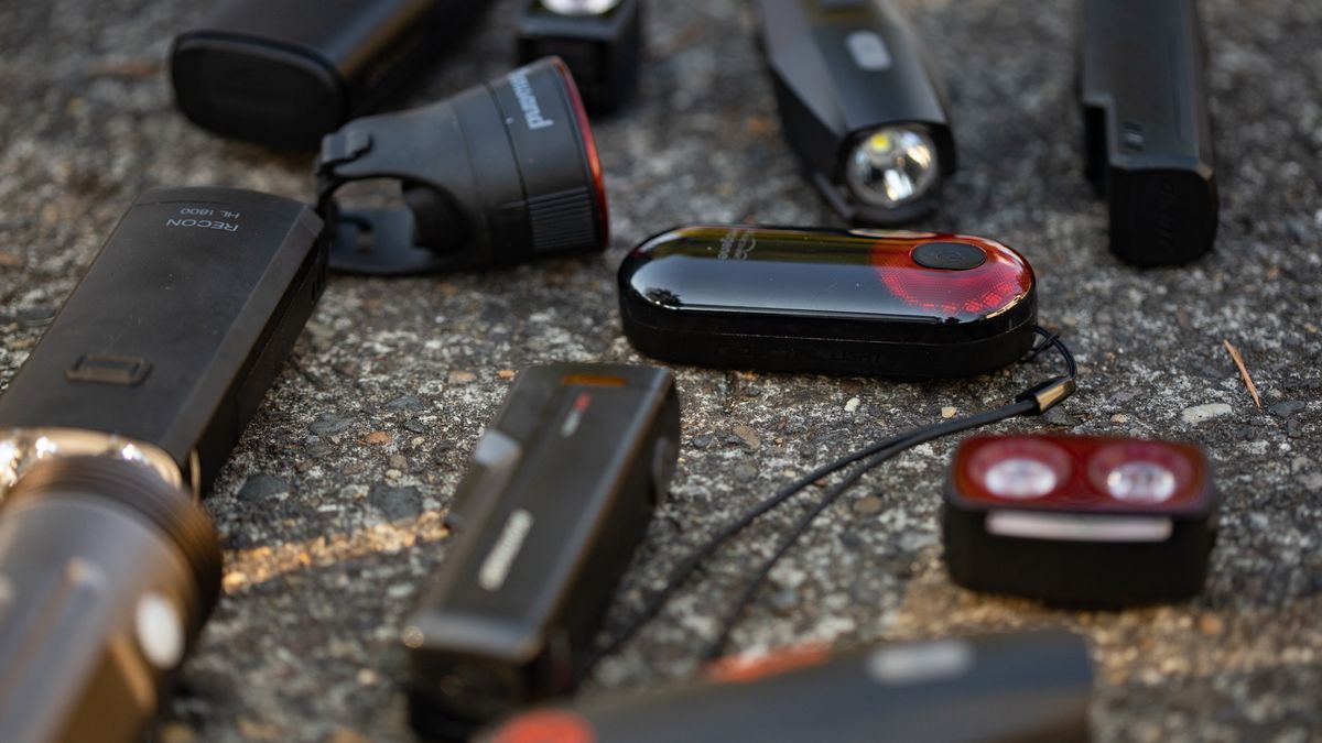 A collection of the best budget bike lights laying on a paved floor