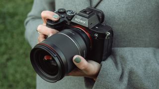 Samyang AF 35mm F1.4 P Sony FE attached to a Sony camera and held in a hand