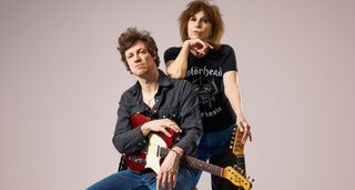 James Walbourne and Chrissie Hynde of the Pretenders pose with Telecasters against a mauve background. Hynde wears a Motörhead T-shirt.