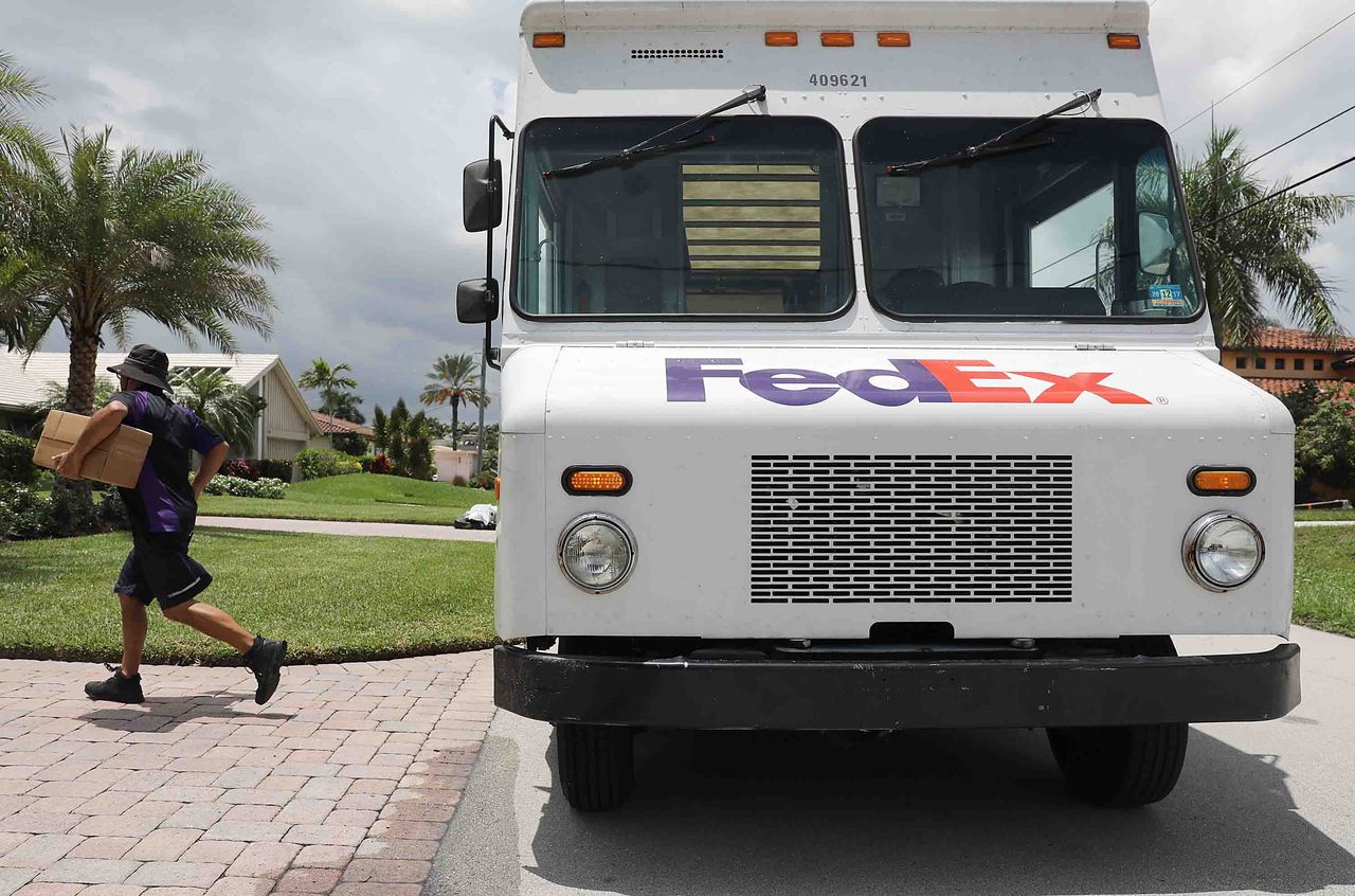 Photo of a Fed Ex driver walking away from the side of his truck