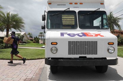Photo of a Fed Ex driver walking away from the side of his truck