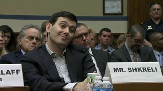A still from a court scene in documentary Pharma Bro in which Martin Shkreli is smiling in a court room.