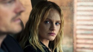 Emma Laird looks at a man sat next to her in a car