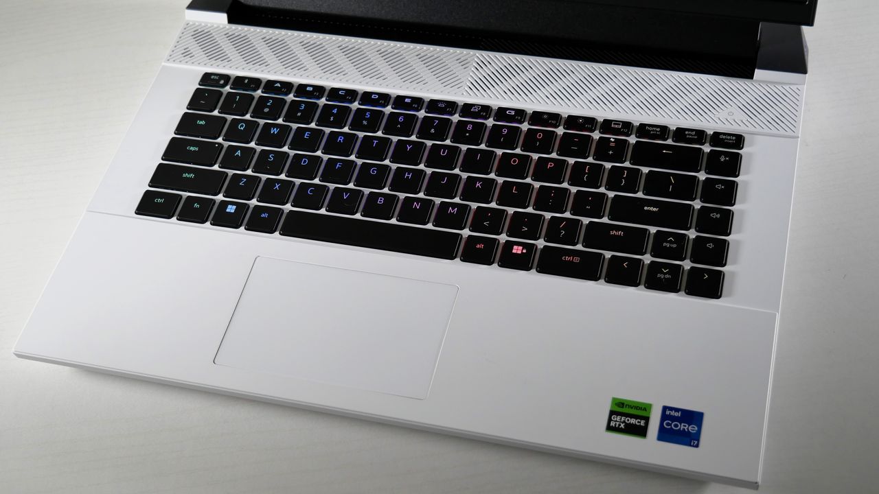 Dell G16 (7630) open on a white table, highlighting the RGB-lit keyboard against its white deck.