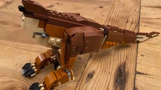 Partially built Lego T. rex Breakout model on a wooden table