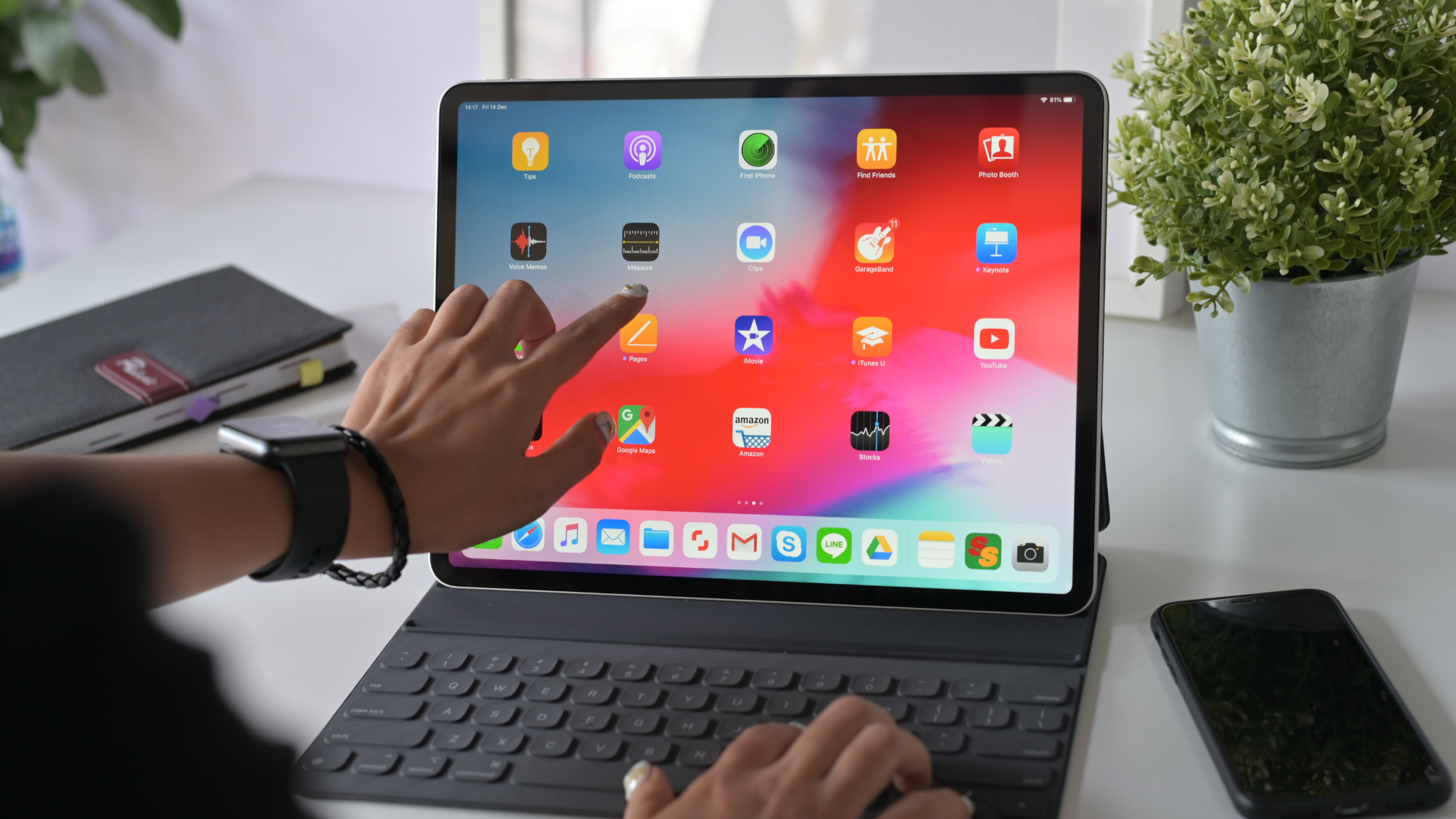 Frau benutzt den Touchscreen eines iPads und gleichzeitig eine Tastatur