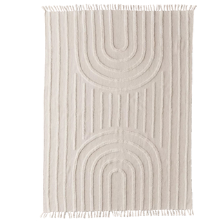 A neutral geometric tufted rug with fringed edges