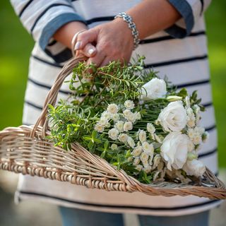 hand holding basket with white flowers