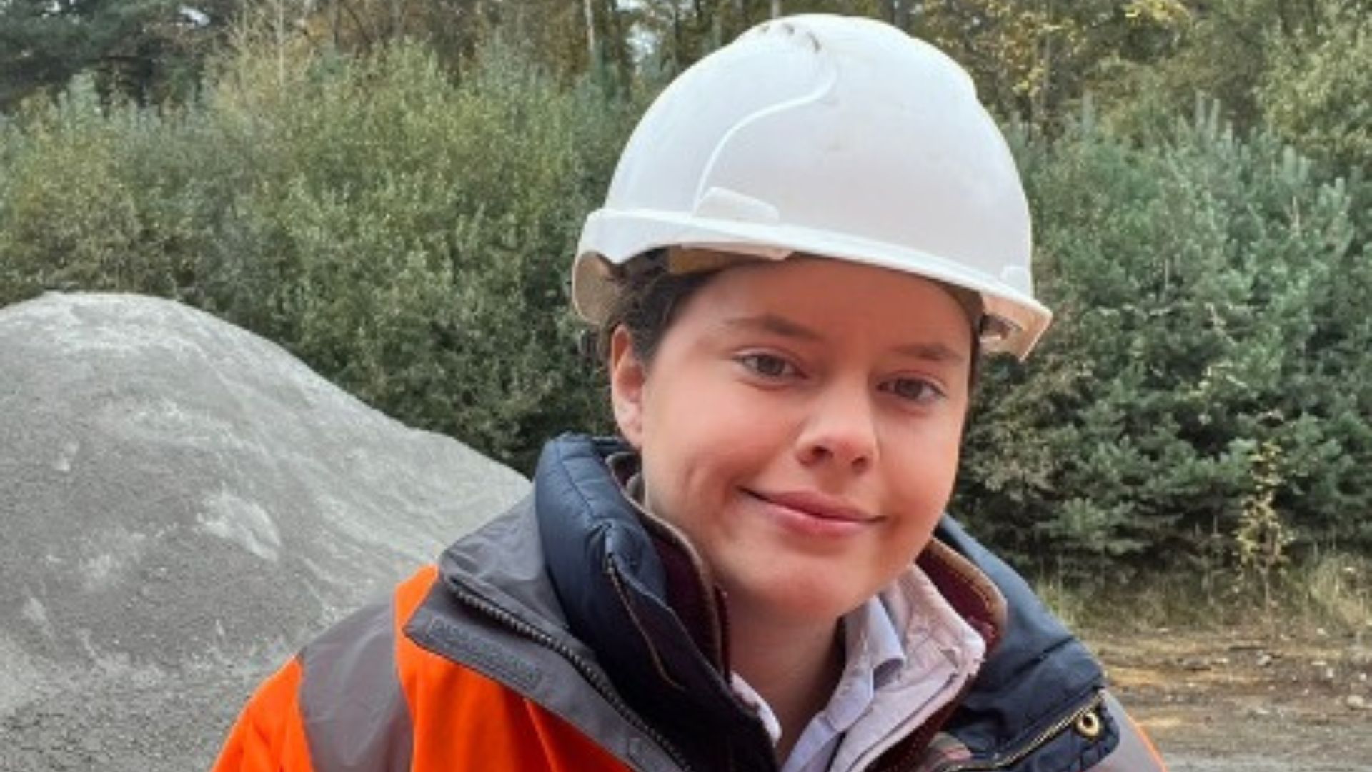 Young woman in a hard hat and high vis jacket