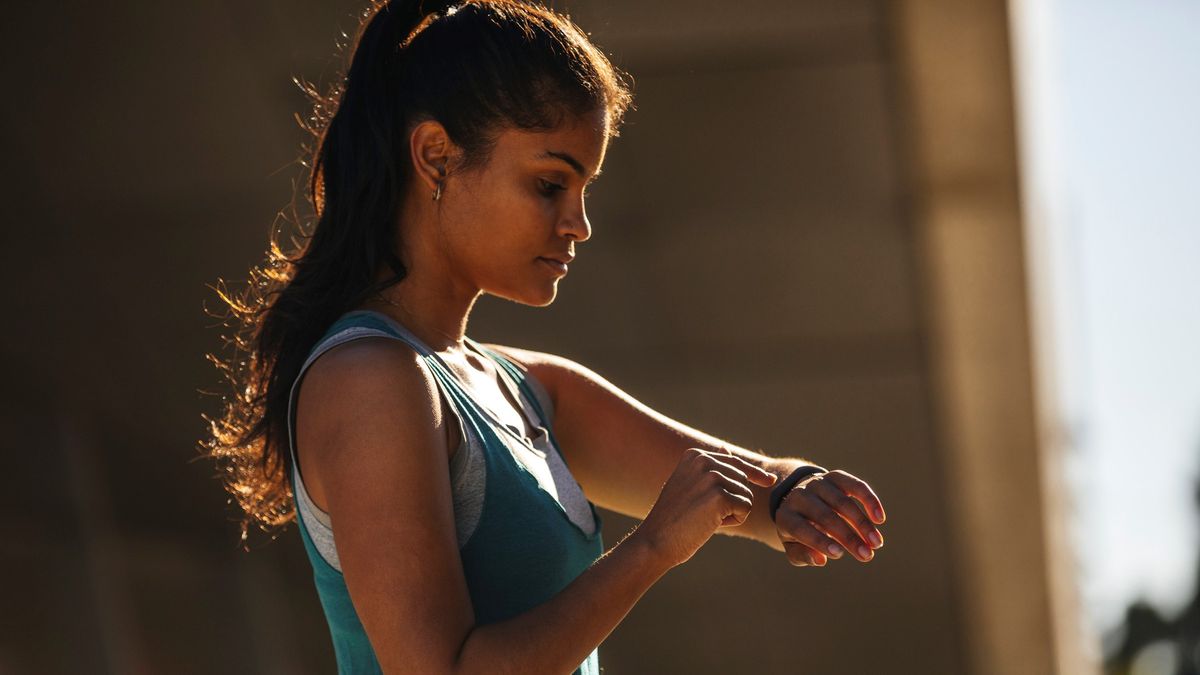 a photo of a woman looking at her running watch