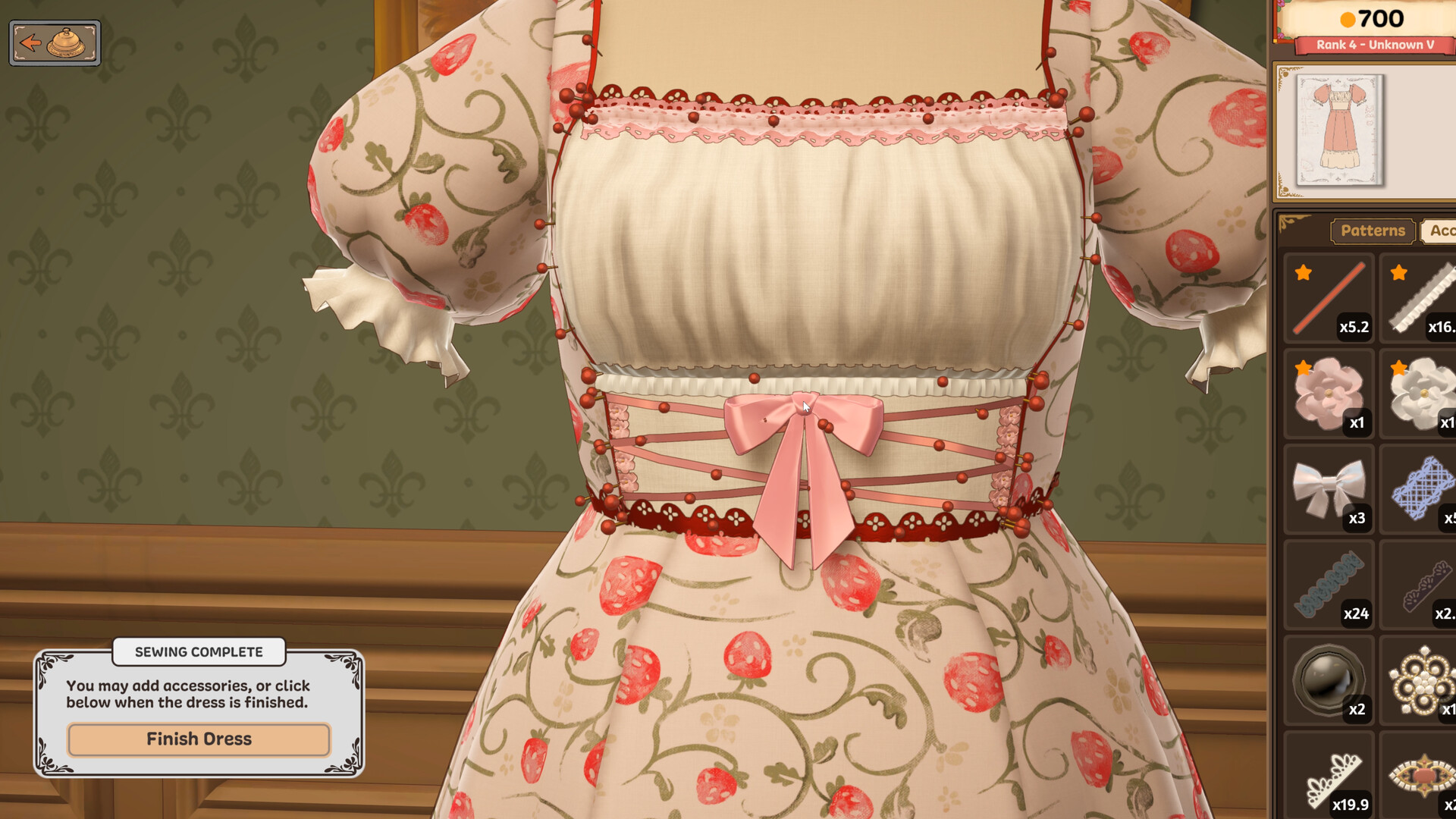 In cozy, crafting simulation game Dressmaker, a menu shows various details that can be sewn onto a dress on a mannequin, which has a strawberry pattern, short puff sleeves, and a pink bowed corset