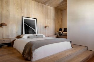 a bedroom with wood walls and the bed sunken into the flor