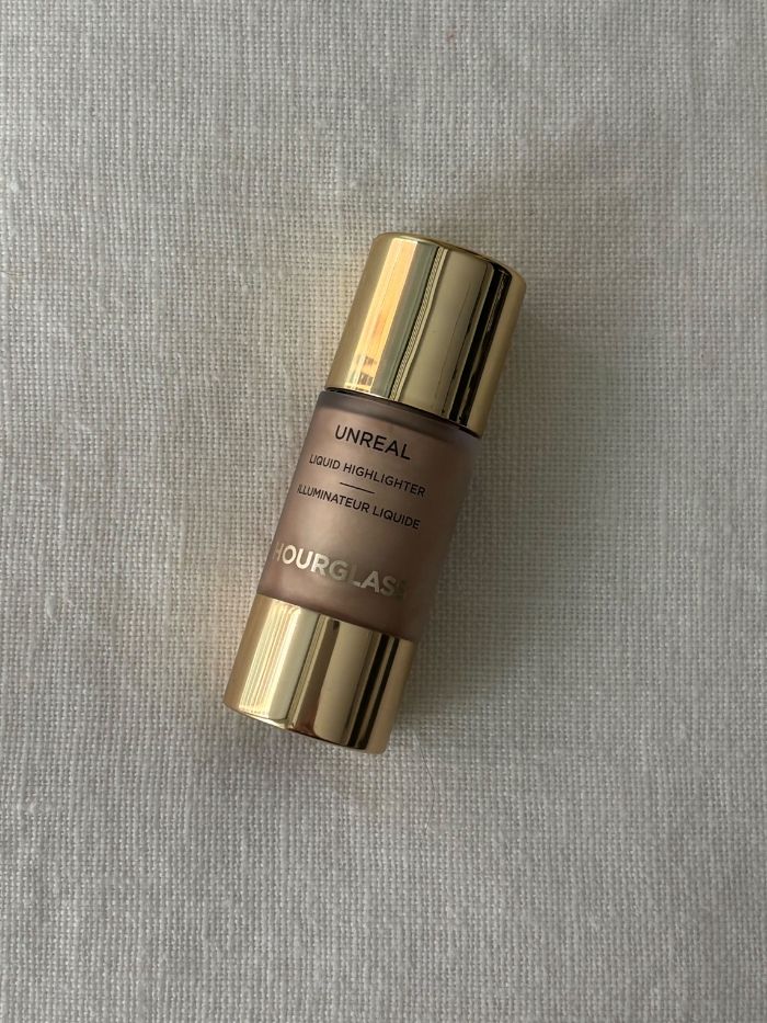 The Hourglass Unreal Liquid Highlighter on a white linen background