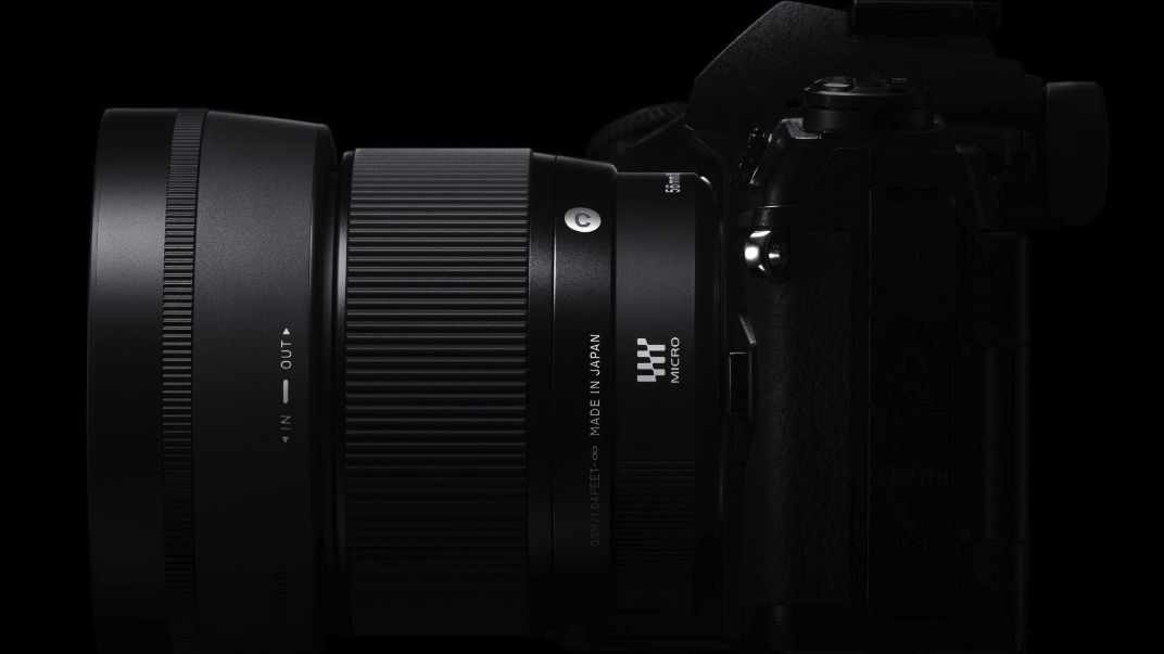 Sigma 56mm f/1.4 contemporary lens attached to a Nikon mirrorless camera, black background