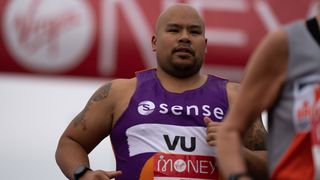 A runner in the London Marathon 2021 wears a running vest with the name of the charity Sense written on it